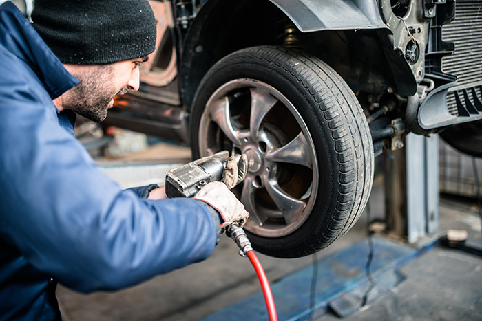 man working on tire of car